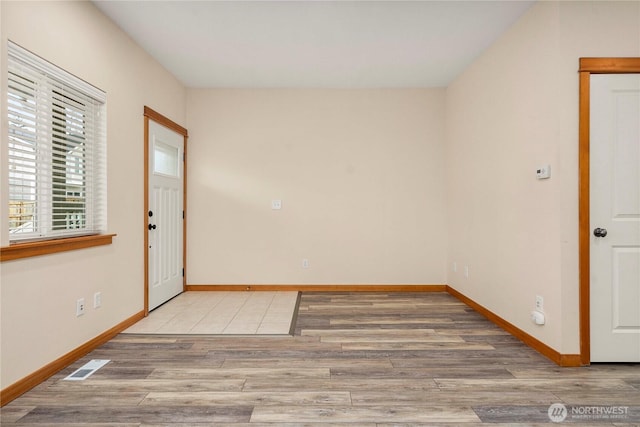 empty room with visible vents, baseboards, and wood finished floors