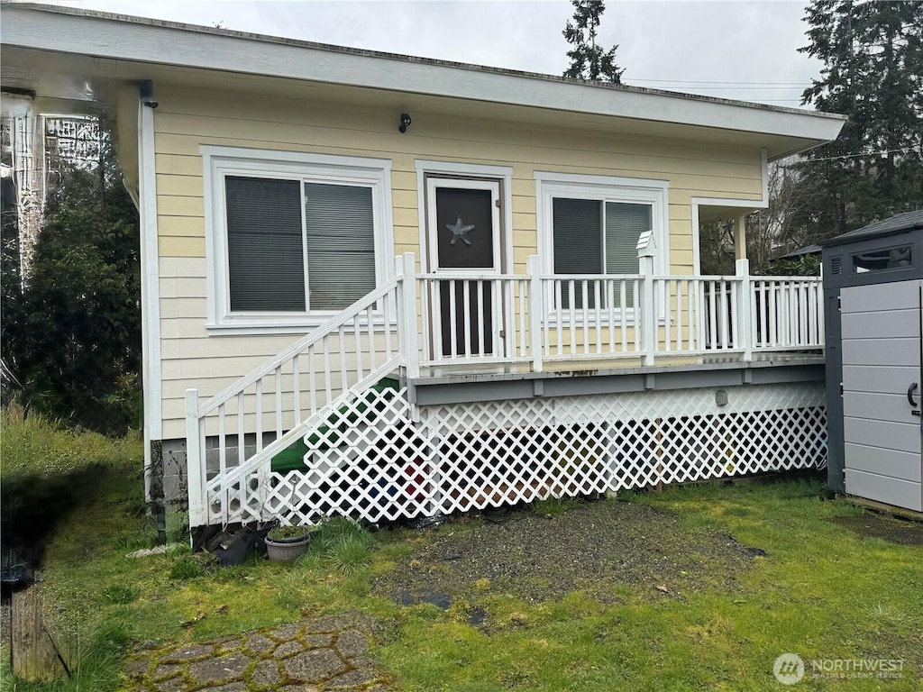 rear view of property with a lawn and a wooden deck