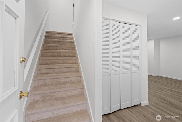 staircase with recessed lighting, baseboards, and wood finished floors