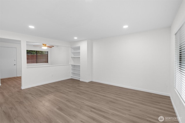 spare room with a ceiling fan, baseboards, wood finished floors, and recessed lighting