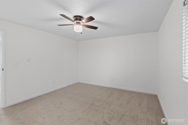 empty room with carpet flooring, ceiling fan, and baseboards