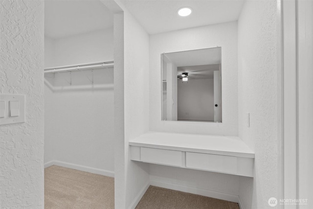 walk in closet featuring a ceiling fan and carpet