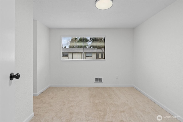 carpeted empty room featuring visible vents and baseboards