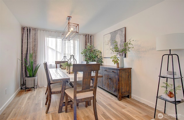 dining area with an inviting chandelier, baseboards, and light wood finished floors