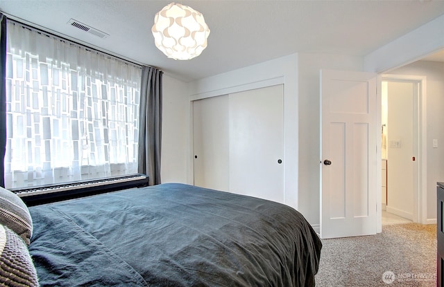 carpeted bedroom with a closet and visible vents