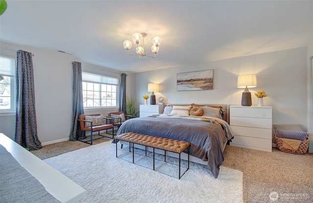 carpeted bedroom featuring baseboards and a chandelier