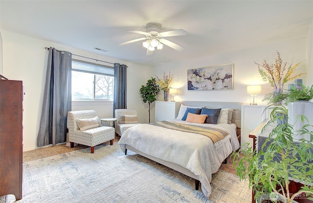 bedroom featuring visible vents, baseboards, light colored carpet, and a ceiling fan