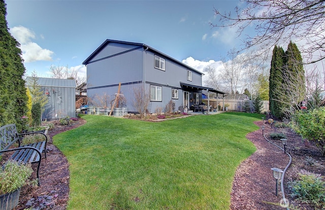 rear view of house with a patio, a yard, and a fenced backyard