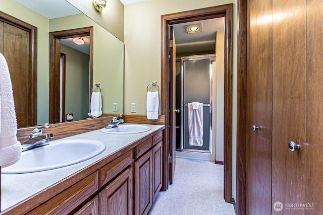 bathroom featuring double vanity, a stall shower, and a sink