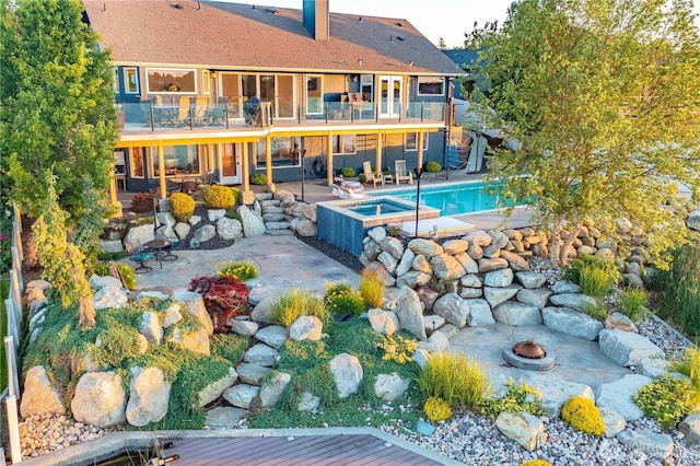 view of pool featuring a fire pit, stairway, a patio area, and a pool with connected hot tub