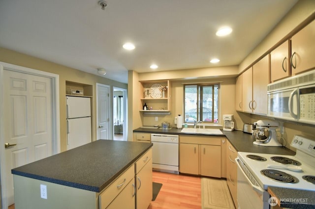 kitchen with white appliances, dark countertops, light wood-style floors, open shelves, and a sink