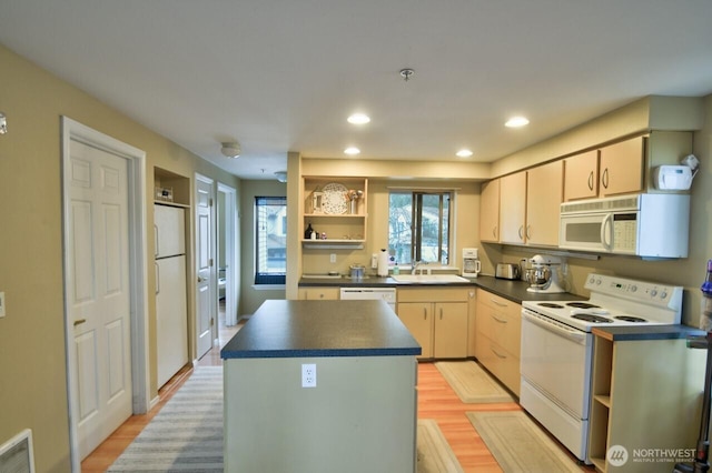 kitchen with white appliances, visible vents, dark countertops, a center island, and open shelves