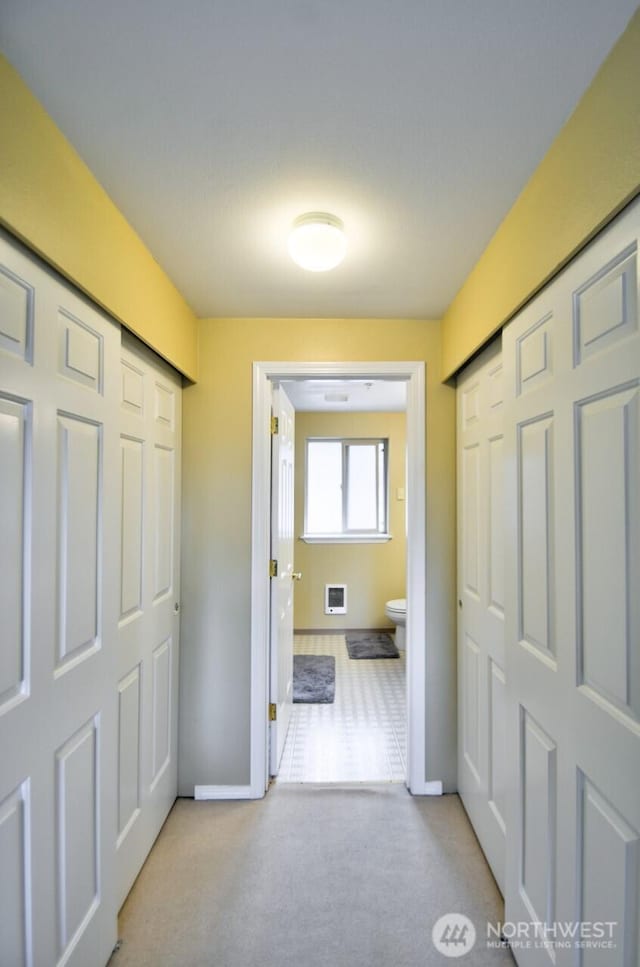 hallway featuring baseboards and carpet flooring