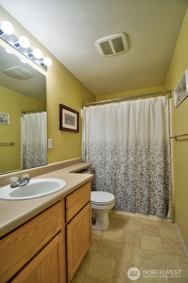 full bath featuring toilet, vanity, and visible vents