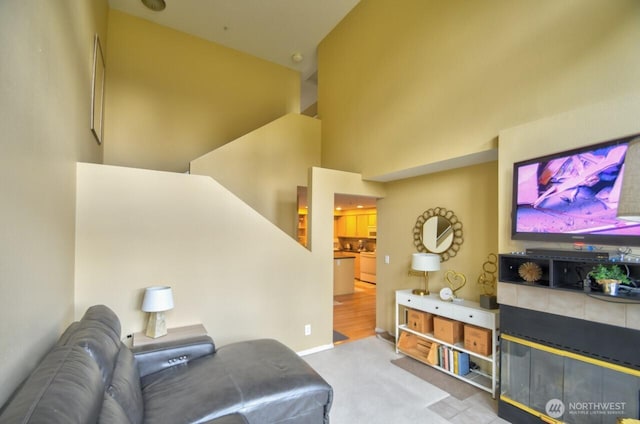 carpeted living area featuring a high ceiling