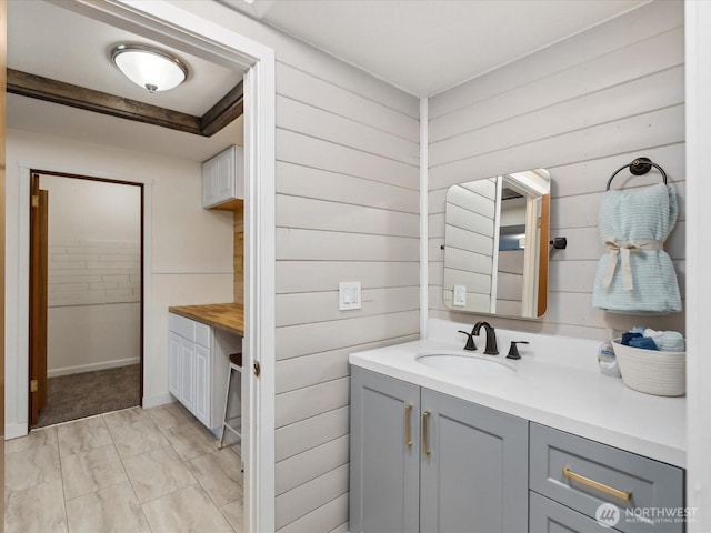 bathroom with wood walls and vanity