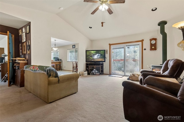 carpeted living room with a wealth of natural light, ceiling fan, and vaulted ceiling