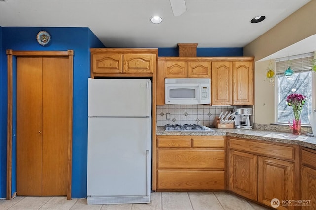 kitchen featuring white appliances, brown cabinetry, light tile patterned flooring, recessed lighting, and backsplash