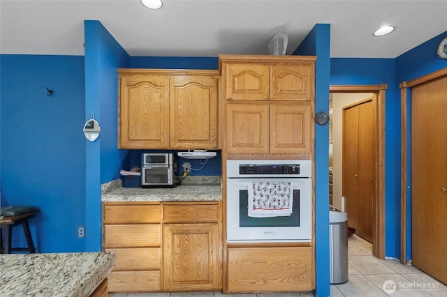 kitchen with oven, recessed lighting, and light tile patterned floors