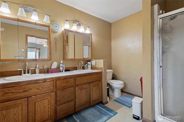 full bathroom with a sink, toilet, a stall shower, and double vanity