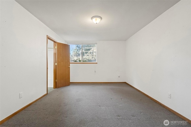 empty room featuring baseboards and carpet floors