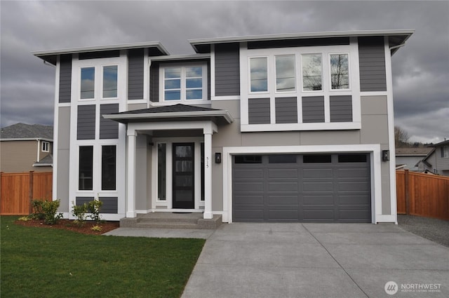 view of front facade featuring driveway, a front lawn, an attached garage, and fence