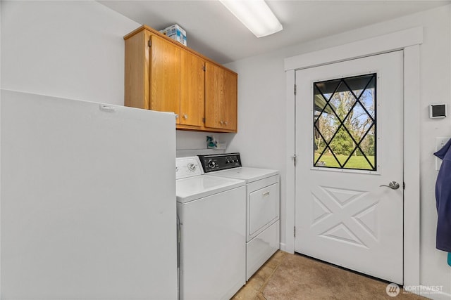 clothes washing area featuring washing machine and clothes dryer and cabinet space