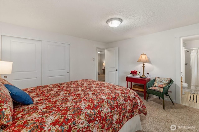 bedroom featuring ensuite bath, carpet, a closet, and a textured ceiling