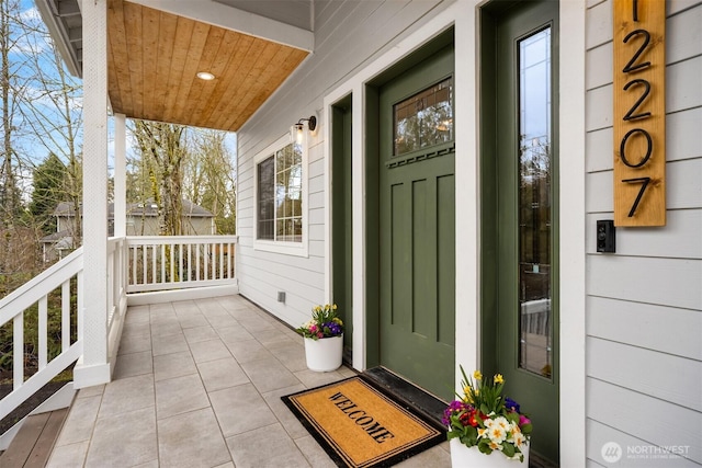 view of exterior entry with a porch and crawl space