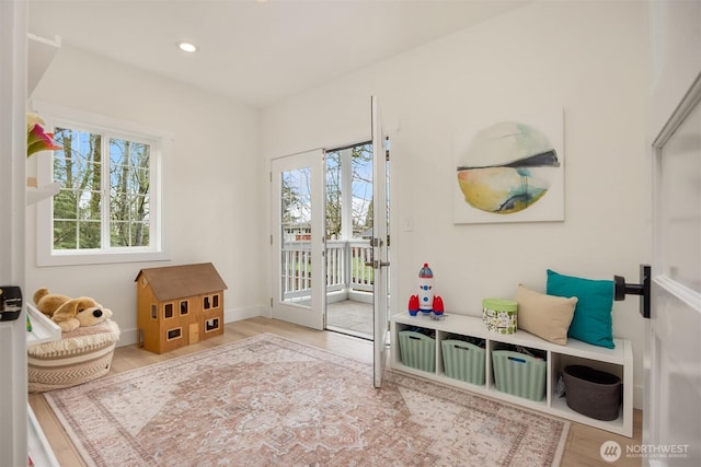 living area with recessed lighting, baseboards, a healthy amount of sunlight, and wood finished floors