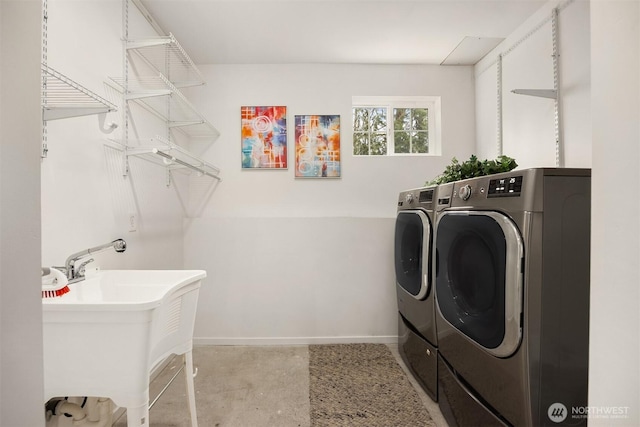 laundry room featuring washer and clothes dryer, laundry area, baseboards, and a sink