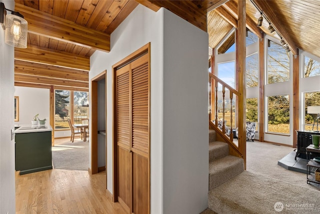 interior space with stairway, high vaulted ceiling, wooden ceiling, beamed ceiling, and baseboards