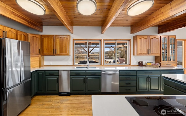 kitchen featuring light countertops, appliances with stainless steel finishes, light wood-style floors, a sink, and wooden ceiling