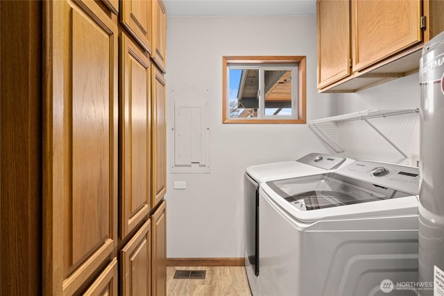 clothes washing area with cabinet space, electric panel, visible vents, baseboards, and washing machine and dryer