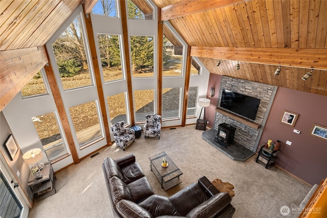 carpeted living room with wood ceiling, high vaulted ceiling, plenty of natural light, and beam ceiling