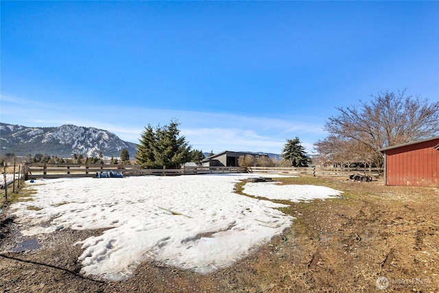 view of yard with a rural view, fence, and a mountain view