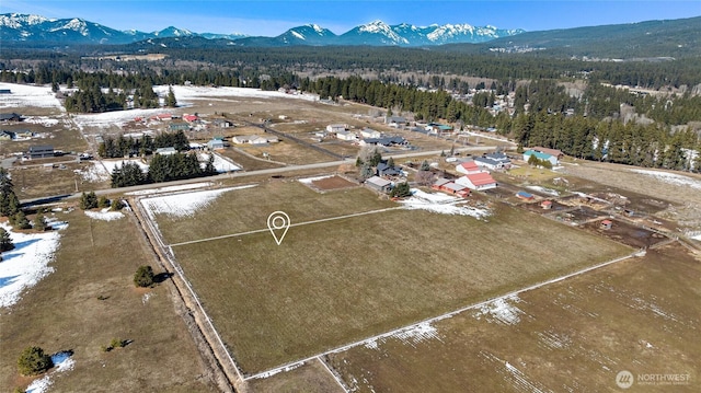 birds eye view of property with a forest view and a mountain view