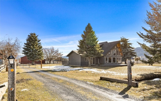 view of front facade featuring driveway and fence