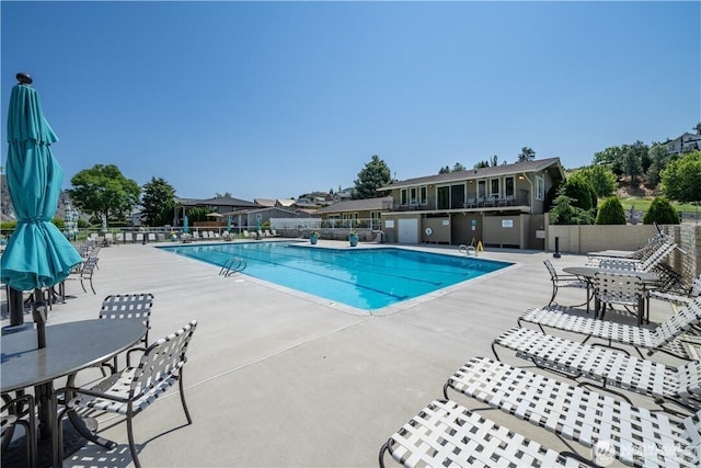 pool with a patio area and fence