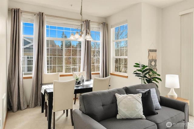 carpeted dining area with a notable chandelier and a healthy amount of sunlight