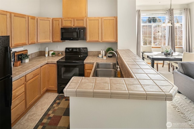 kitchen featuring tile countertops, black appliances, light brown cabinets, and a sink