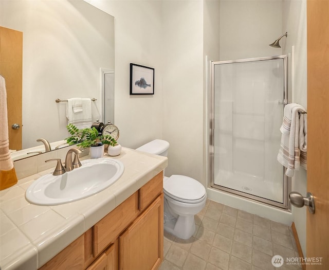 bathroom with a shower stall, toilet, and vanity