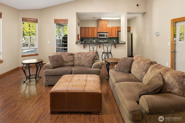 living area with wood finished floors and vaulted ceiling