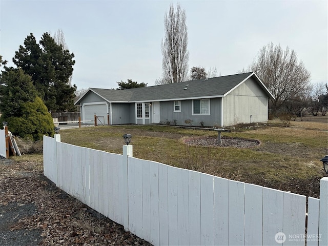 ranch-style home with a garage, fence, and a front lawn