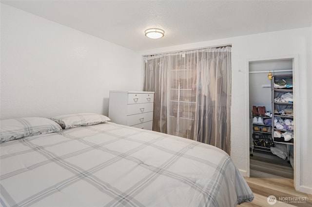 bedroom featuring a textured ceiling and wood finished floors