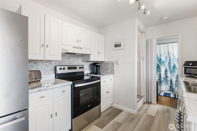 kitchen featuring light wood-style flooring, under cabinet range hood, backsplash, stainless steel appliances, and white cabinets