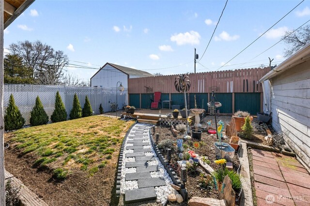 view of yard with a vegetable garden, a wooden deck, and a fenced backyard