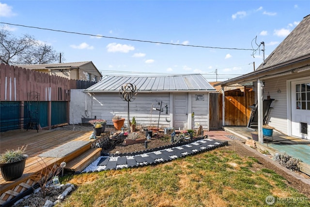 view of yard with an outbuilding, a wooden deck, and fence