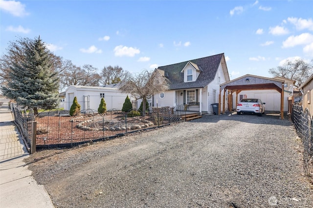 view of front of house featuring covered porch, a detached carport, fence private yard, and driveway