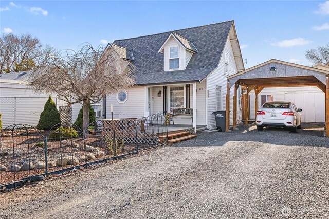 view of front of property with fence, a carport, gravel driveway, and a shingled roof